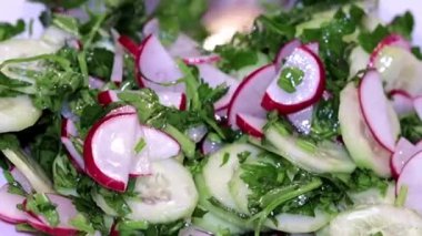ince kıyılmış taze turp ve salatalık otlar ile bir tabak içinde bir kaşıkla karıştırarak 