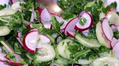 ince kıyılmış taze turp ve salatalık otlar ile bir tabak içinde bir kaşıkla karıştırarak 