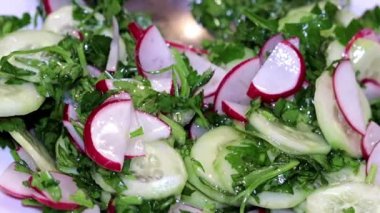 ince kıyılmış taze turp ve salatalık otlar ile bir tabak içinde bir kaşıkla karıştırarak 