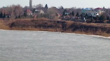 Bir buz kaplı nehir kıyısında kırsal konutlarında 