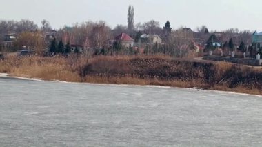 Bir buz kaplı nehir kıyısında kırsal konutlarında 