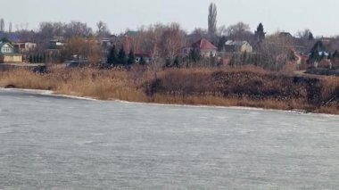 Bir buz kaplı nehir kıyısında kırsal konutlarında 