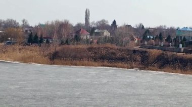 Bir buz kaplı nehir kıyısında kırsal konutlarında 