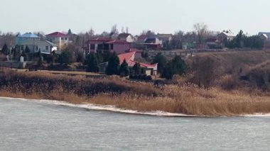 Bir buz kaplı nehir kıyısında kırsal konutlarında 