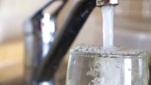 きれいな飲料水のジェットが蛇口からガラスをいっぱい — ストック動画