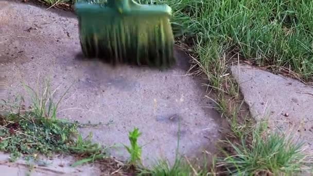 Spazzare Spazzatura Con Una Scopa Sulla Strada Del Giardino — Video Stock