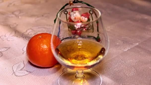 正月飾りとタンジェリンのテーブルの横に強いアルコールのガラス — ストック動画
