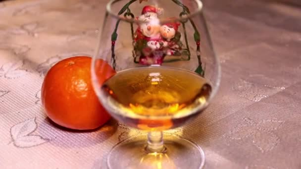 正月飾りとタンジェリンのテーブルの横に強いアルコールのガラス — ストック動画