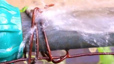 Metal ve plastik boru kavşağında Jet ve su damlacıkları