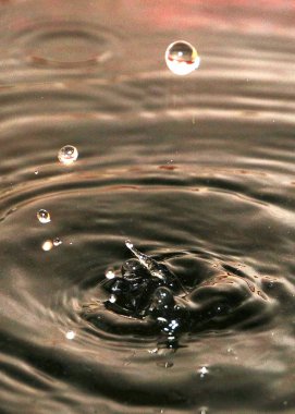 Bir varil petrolün yüzeyinde su sıçramalarına ve damla