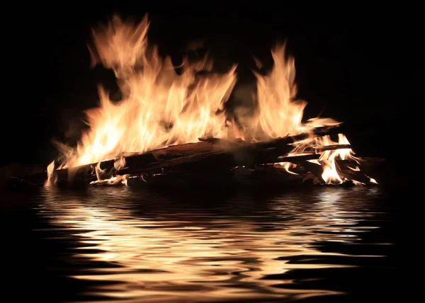 水面上燃烧沉船残骸的明亮火焰 — 图库照片