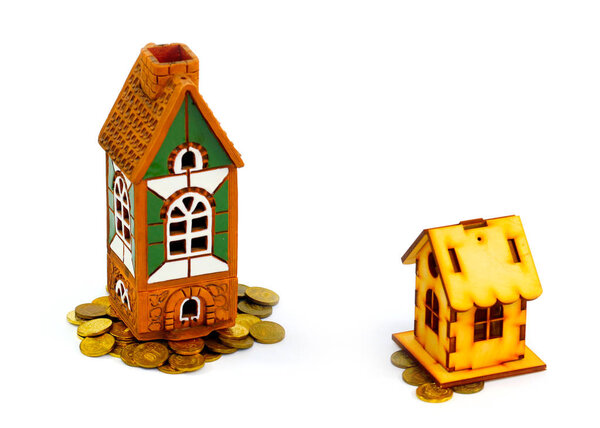 brick house and a wooden hut on a pile of Russian coins as a symbol of the difference of investments