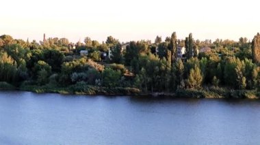 çimenli sakin bir nehir kenarına rustik binalar