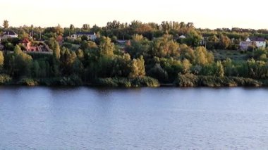 çimenli sakin bir nehir kenarına rustik binalar