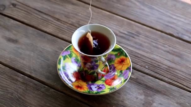 杯与浓烈的红茶站在一个木制的乡村的桌子 — 图库视频影像