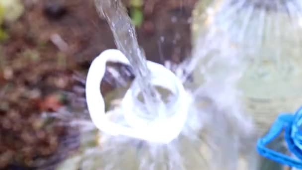 Befüllung Von Plastikflaschen Mit Sauberem Trinkwasser Aus Einem Gummischlauch — Stockvideo