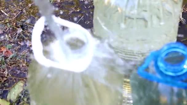 Befüllung Von Plastikflaschen Mit Sauberem Trinkwasser Aus Einem Gummischlauch — Stockvideo