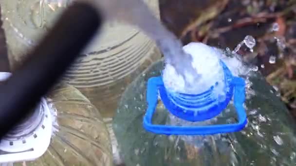Fyller Plastflaskor Med Rent Vatten Från Gummislang — Stockvideo