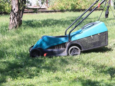 bir çayır bir çim biçme makinesi ile sulu yeşil çim biçme