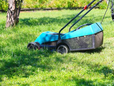 bir çayır bir çim biçme makinesi ile sulu yeşil çim biçme