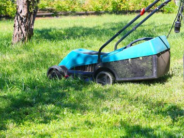 bir çayır bir çim biçme makinesi ile sulu yeşil çim biçme