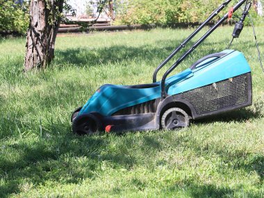 bir çayır bir çim biçme makinesi ile sulu yeşil çim biçme