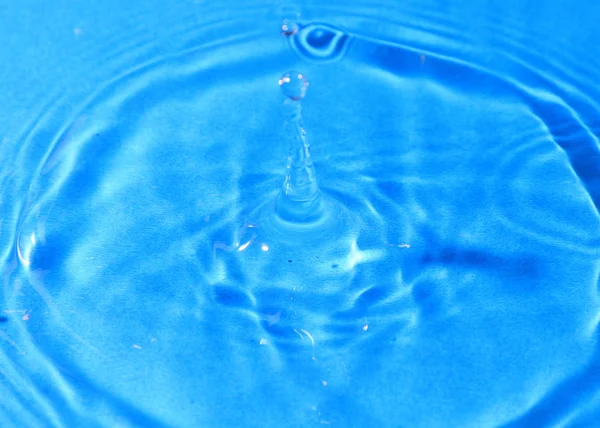 純粋な水の滴が影響の後 液体の表面上の美しいパターンをペイントします — ストック写真