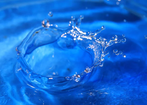 一滴纯净的水创造了幻想模式时 击中了液体的表面 — 图库照片