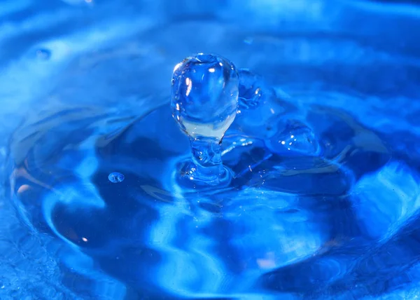 一滴纯净的水创造了幻想模式时 击中了液体的表面 — 图库照片
