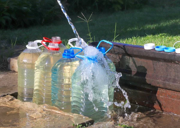 pouring clear water into plastic bottles