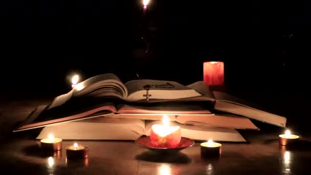 用燃烧的蜡烛和金色十字架点燃的老教堂书籍 — 图库视频影像