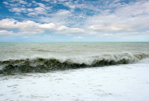 sandy pebble beach and stormy waves of the sea