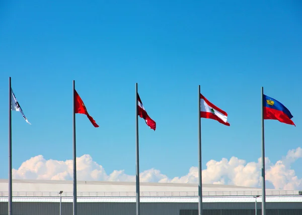 Nationalflaggen Auf Fahnenmasten Vor Dem Hintergrund Des Sommerhimmels — Stockfoto