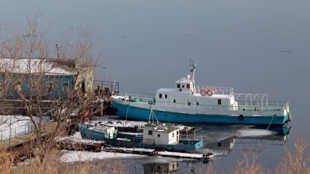 冬の川と小さな船の雪に覆われた海岸 — ストック動画