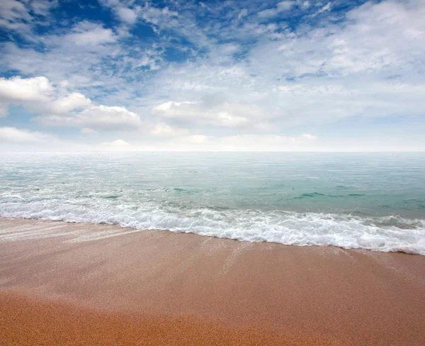 kumlu plaj ve bulutlu gökyüzü ufukta