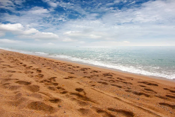 kumlu plaj ve bulutlu gökyüzü ufukta