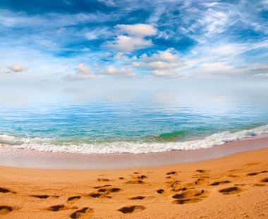 Kumsalı yaz güneşli gökyüzü altında