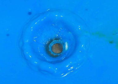 bir damla bir sıvı yüzeyde düşüyor sonra boya