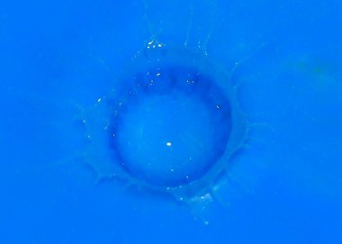 bir damla bir sıvı yüzeyde düşüyor sonra boya