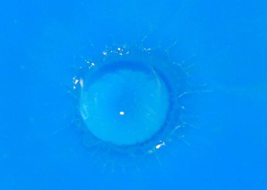 bir damla bir sıvı yüzeyde düşüyor sonra boya