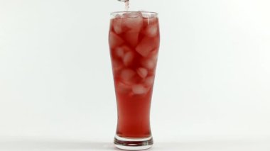 buz küpleri ile dolu bir bardağa meyve suyu dökme