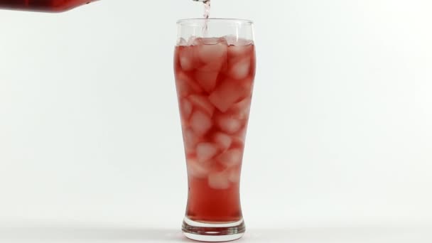 氷の立方体で満たされたガラスにジュースを注ぐ — ストック動画