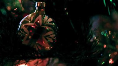 Aydınlatılmış bir Noel ağacının dallarında güzel cam oyuncaklar