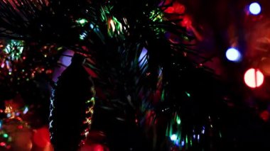 Aydınlatılmış bir Noel ağacının dallarında güzel cam oyuncaklar