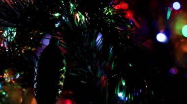 Aydınlatılmış bir Noel ağacının dallarında güzel cam oyuncaklar