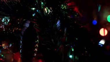Aydınlatılmış bir Noel ağacının dallarında güzel cam oyuncaklar