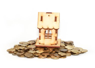 İpotek kredisinin sembolü olarak altın paraların üzerindeki ahşap ev