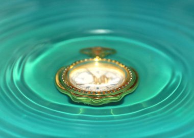 altın bir durumda bir vintage saat berrak suda damla