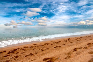 güneşli bir gökyüzü altında Akdeniz'in kumlu plaj