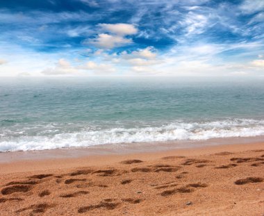 güneşli bir gökyüzü altında Akdeniz'in kumlu plaj